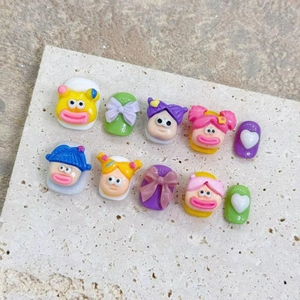 Gros plan de charms 3D visages de dessin animé et nœuds en résine colorés pour le nail art