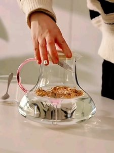 Detail of high borosilicate glass pitcher with elegant pink handle for floral tea brewing