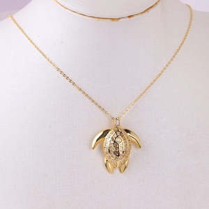 Detailed view of a gold sea turtle pendant necklace with colorful rectangular zircon stones