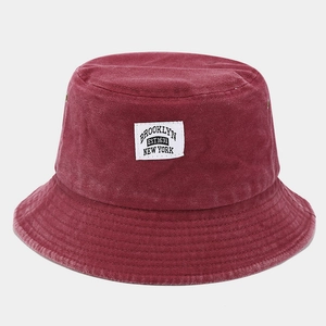 Detail view of burgundy washed denim bucket hat with Brooklyn fabric patch and metal eyelets