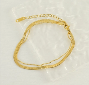 Detailed macro view of 18K gold plated double-layer herringbone and bead chain anklet