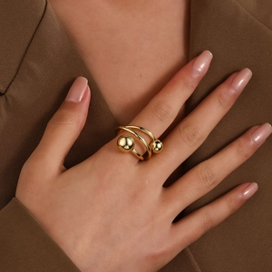 Detail of 18k gold plated triple layer wire ring with hollow ball design on model finger