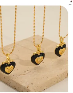 Detailed view of black enamel heart pendants with gold plating and zircon inlay details