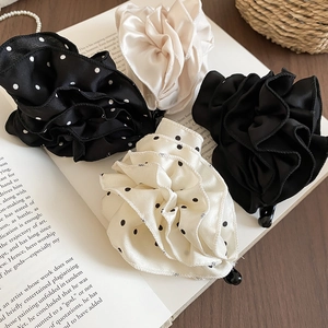 Détail des barrettes fleurs en tissu acrylique avec pois et texture plissée élégante