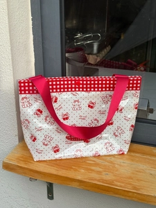 Detail of waterproof PVC tote bag with red cherry prints and cute doggy illustration