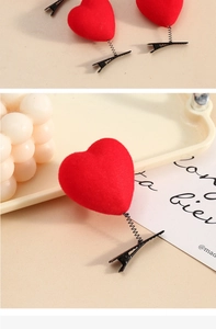 Detailed close-up of red flocked heart hair clip with spring attachment and metal duckbill clip