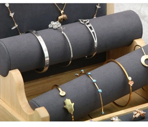 Macro view of multi-tier bamboo and gray velvet jewelry display for necklaces and rings