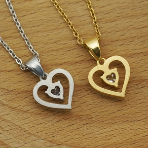 Double heart zircon necklaces in gold and silver finish on a wooden background