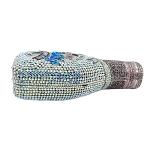 Close-up of a champagne bottle evening clutch encrusted with colorful rhinestones