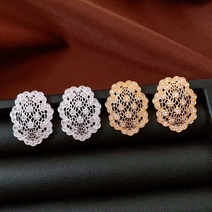 Detailed macro view of gold and silver vintage earrings with hollow patterns and cubic zirconia