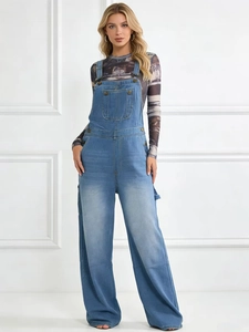 Détail de la salopette en denim bleu clair avec boucles métalliques et poche poitrine