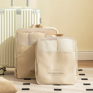 Two-piece beige travel organizers with breathable mesh panels by white suitcase
