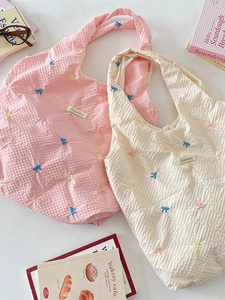 Quilted seersucker shoulder bags with colorful bow embroidery in pink and cream beige