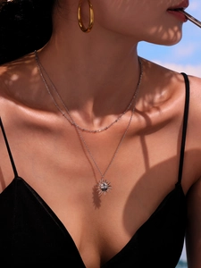 Detail of silver double-layer sun goddess pendant necklace on model's neck