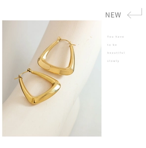 Close-up of polished U-shaped earrings in 18k gold plating with a mirror finish