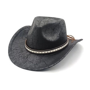 Dettaglio di cappello cowboy nero con trama in pelle screpolata e rivetti a stella