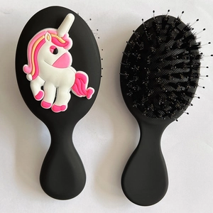 Detail view of black kids paddle brush featuring a 3D unicorn and flexible massage bristles