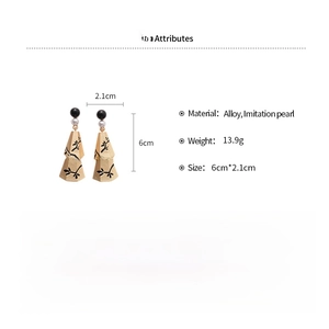 Macro view of metallic pearl tassel earrings with intricate bellflower branch details