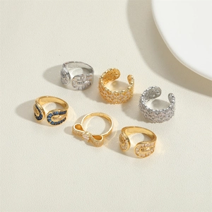 Close-up of 14k gold-plated rings with blue stones and zircons on a textured fabric background