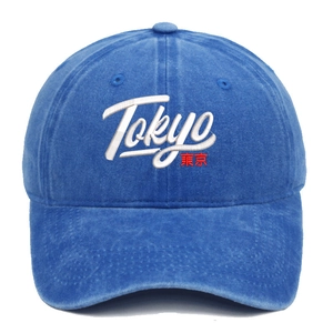 Detail of embroidered Tokyo letters on a washed dark blue cotton baseball cap