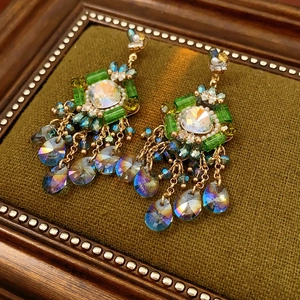 Macro view of vintage bohemian tassel earrings with emerald gems and colorful crystals