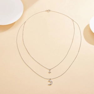 Close-up of S925 sterling silver double-layered necklace with star and moon pendants