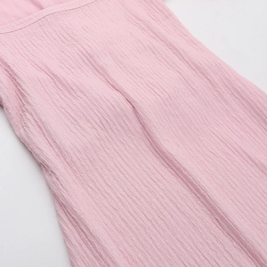 Detailed close-up of pink textured pleated fabric showing elegant material grain