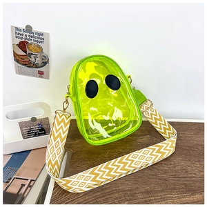 Detail of neon yellow transparent PVC jelly bag with black round decor and wide strap