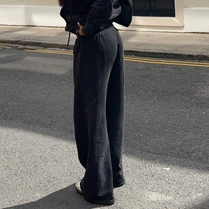 Détail de la taille à cordon et de la coupe large de ce pantalon en maille noire décontracté
