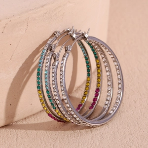 Detailed macro view of silver hoop earrings inlaid with vibrant colorful rhinestones