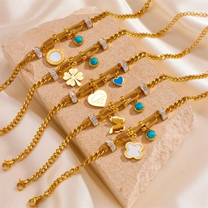 Detail of gold-plated stainless steel charms with turquoise beads and zircon on elegant fabric
