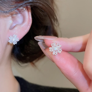 Macro shot of silver needle flower earrings with sparkling cubic zirconia crystals