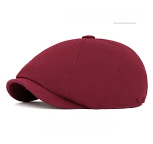 Detailed close-up of wine red newsboy cap showing twill fabric texture and top button