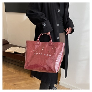 Detail of burgundy tote bag with transparent PVC outer and paper-textured inner layer