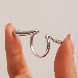 Irregular wavy silver open ring in polished stainless steel for a modern artistic look