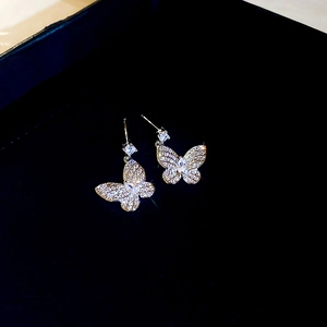 Macro shot of gold-plated butterfly stud earrings with sparkling zircon inlay details