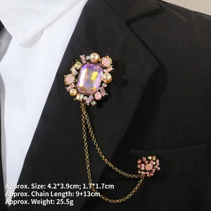 Détail d'une broche baroque avec cristal violet et chaînes sur un costume noir