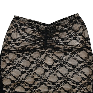 Gros plan sur le tissu en dentelle florale noire avec doublure chair et détails froncés