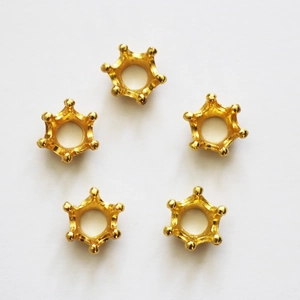 Detailed view of five golden crown-shaped six-prong jewelry settings for DIY craft