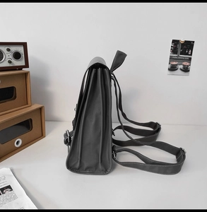 Side view of grey vintage soft leather backpack showing side accordion folds and straps