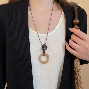 Vintage amber resin hoop pendant necklace with handwoven clover knot on a brown cord