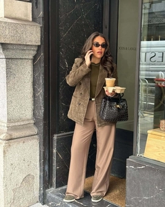 Scatto street style di un blazer scamosciato verde oliva con pantaloni kaki larghi