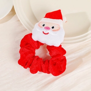 Detail view of a plush Santa Claus ornament on a red velvet Christmas hair scrunchie