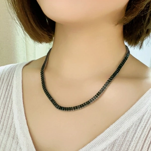 Elegant silver tennis necklace with black rectangular crystals worn by a model