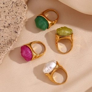 Close-up of gold stainless steel rings with assorted colorful irregular resin stones