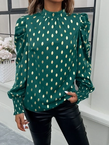 Detail of dark green satin blouse with gold polka dots and elegant puff sleeve cuffs