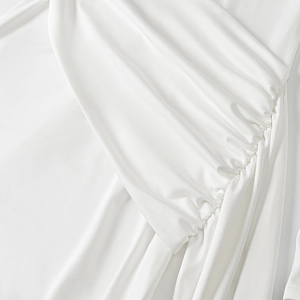Close-up of elegant ruched white chiffon dress showing fine draping and soft texture