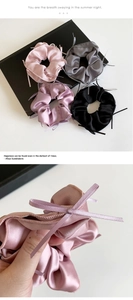 Detailed view of glossy satin scrunchies with ribbons in four elegant colors