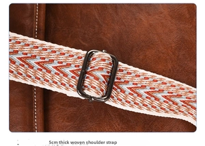 Detail of 5cm wide woven shoulder strap with geometric patterns on leather backpack