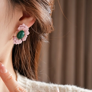 Vintage floral drop earrings with pink petals and green gemstone on female model